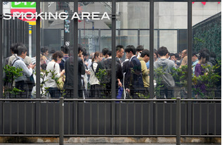 喫煙エリアでたばこを吸う人＝資料（ＥＰＡ時事）